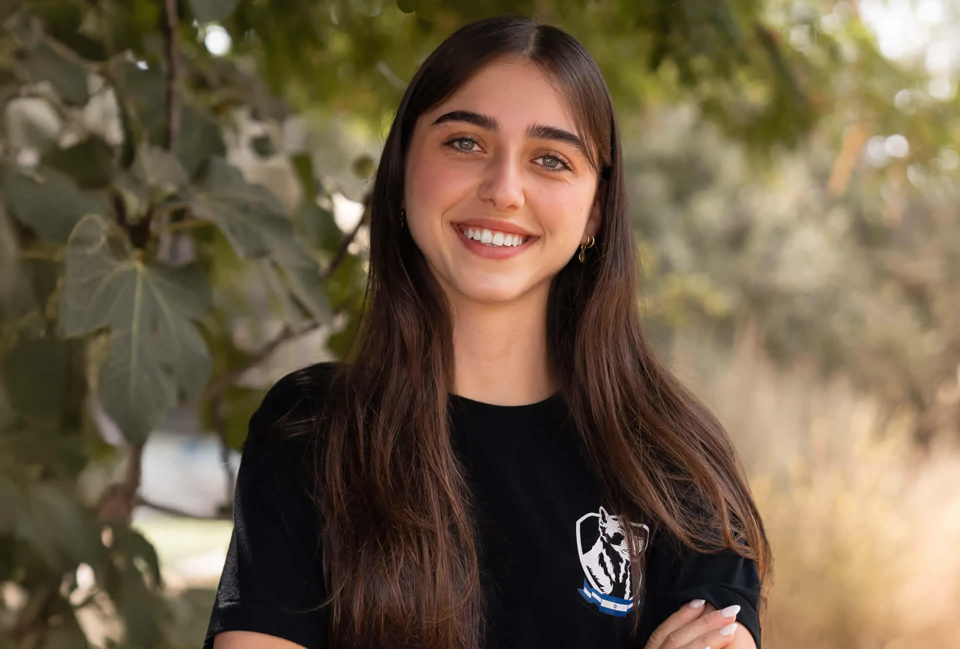 Agam Buadana, Israel Protection K9 team member, smiling portrait in natural setting.